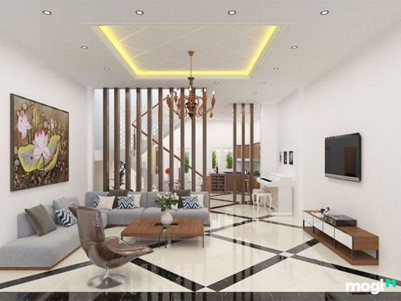 Phòng khách với đèn trần cầu kỳ và tranh treo tường bản lớn tạo điểm nhấn cho ngôi nhà