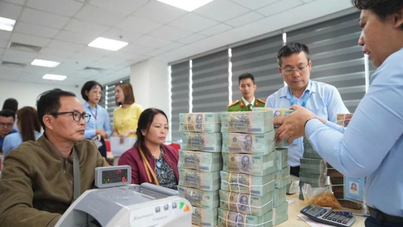 Người dân đang được bàn giao số tiền đền bù khi bị thu hồi đất. (Ảnh: Kenh14)